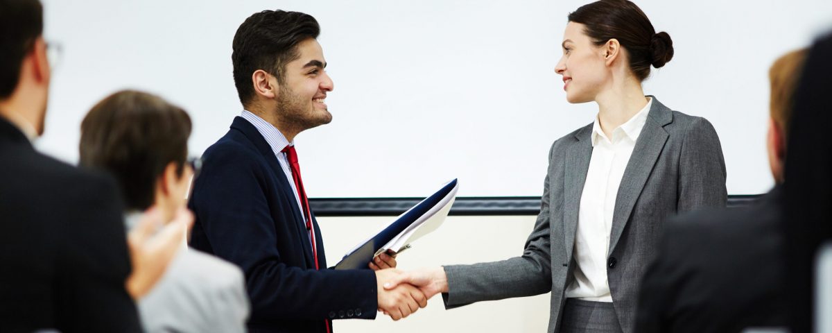 Coach congratulating one of business course attendants on graduation event